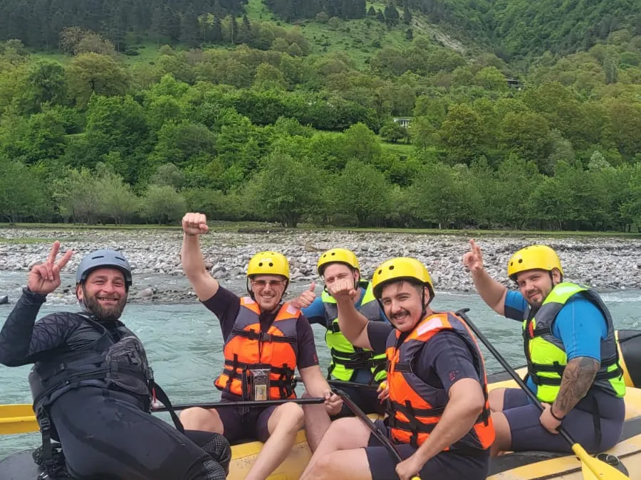 Happy rafting group waving from a raft on the White Aragvi