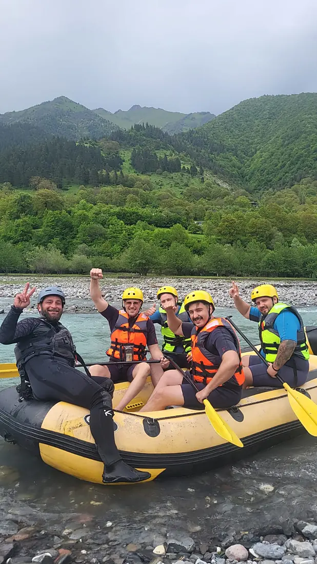 Group waving from a raft on a calm stretch of the White Aragvi