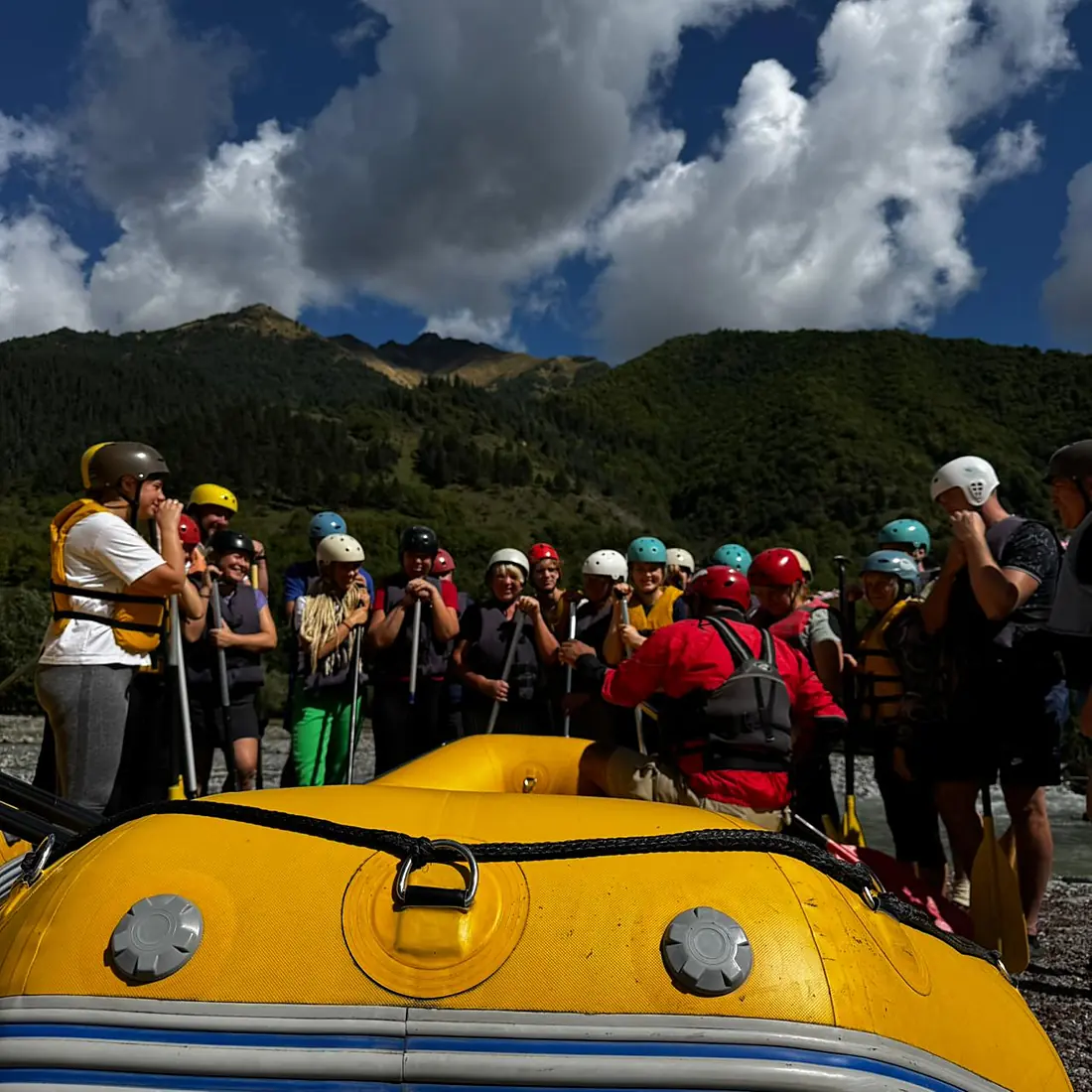 Rafters with helmets and life jackets lined up at the camp