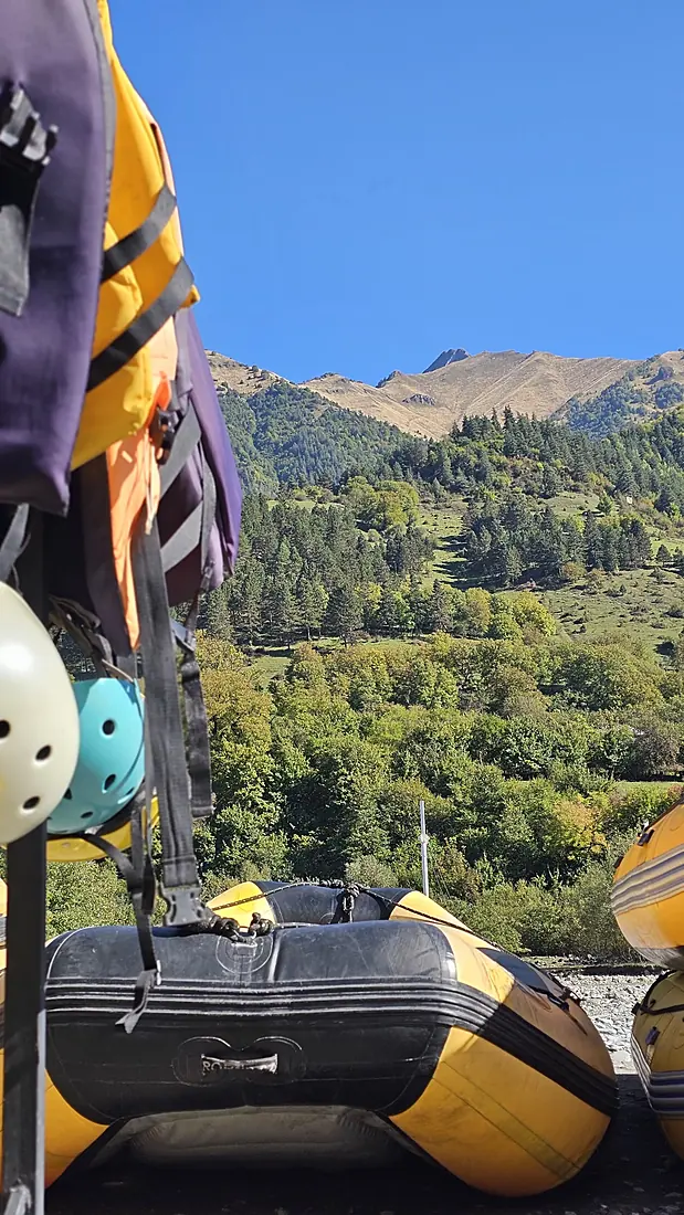 Rafts and helmets stacked against the mountain backdrop