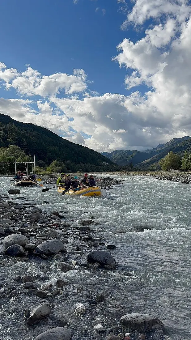 Rafts heading downriver under a big mountain sky